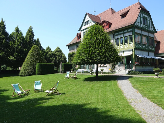Museum Langmatt mit Liegestühlen für die Gäste auf der grossen besonnten Rasenfläche.